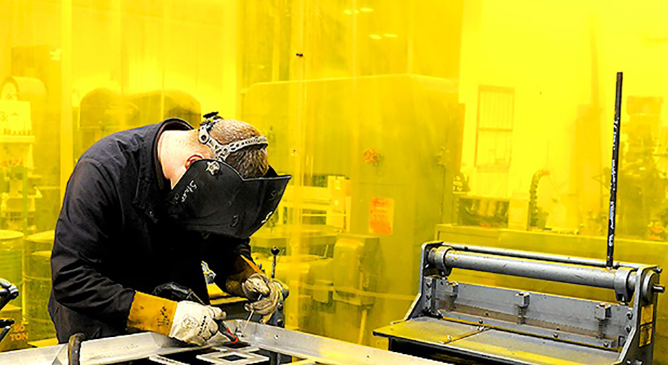 Welder working on a project at NextFab makerspace
